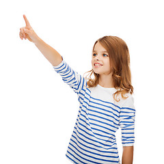 Image showing smiling girl pointing at virtual screen