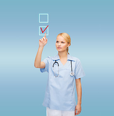 Image showing doctor or nurse drawing checkmark into checkbox