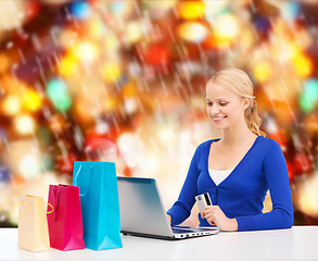 Image showing woman with laptop, shopping bags and credit card