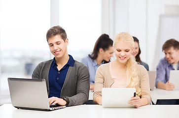 Image showing two smiling students with laptop and tablet pc