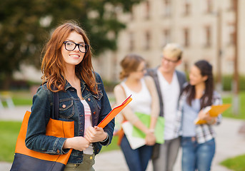 Image showing female student in eyglasses with folders
