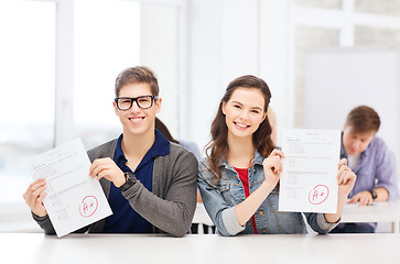 Image showing two teenagers holding test or exam with grade A