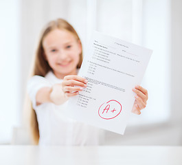 Image showing smiling little student girl with test and A grade