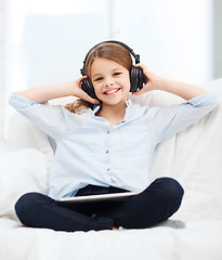 Image showing girl with tablet pc and headphones at home