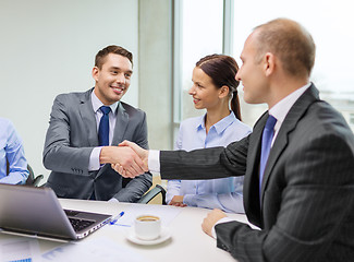 Image showing two businessman shaking hands in office
