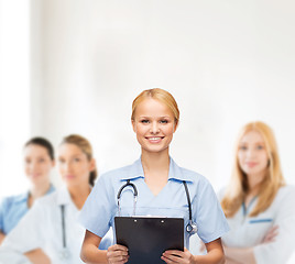 Image showing smiling female doctor or nurse with clipboard