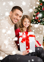 Image showing smiling father and daughter holding gift box