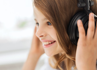 Image showing smiling little girl with headphones at home