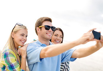 Image showing group of friends taking picture with smartphone