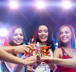 Image showing three smiling women with cocktails and disco ball