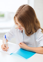 Image showing student girl writing in notebook at school