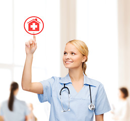 Image showing smiling doctor or nurse pointing to hospital icon