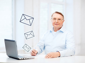 Image showing old man in eyeglasses filling a form at home