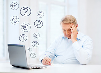 Image showing old man filling a form at home