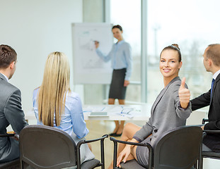 Image showing businesswoman with team showing thumbs up