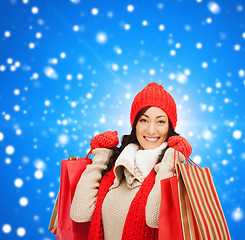 Image showing smiling woman in warm clothers with shopping bags