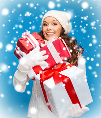 Image showing woman in sweater and hat with many gift boxes
