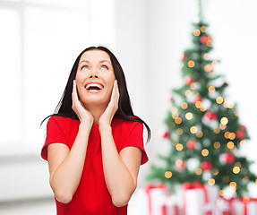 Image showing amazed laughing young woman in red dress