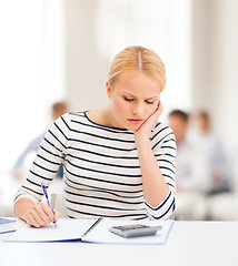 Image showing woman with notebook and calculator studying