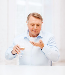 Image showing old man with pills ang glass of water