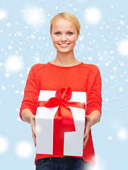 Image showing smiling woman in red sweater with gift box