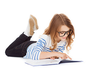 Image showing smiling little student girl lying on the floor