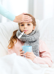 Image showing ill girl child with thermometer and caring mother