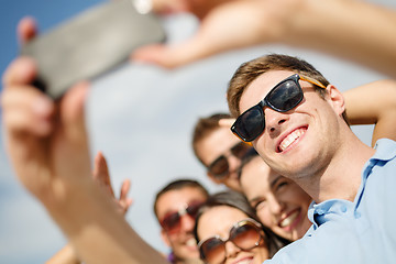 Image showing group of friends taking picture with smartphone