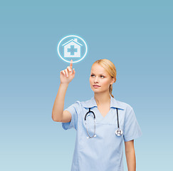 Image showing smiling doctor or nurse pointing to hospital icon