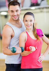 Image showing two smiling people working out with dumbbells