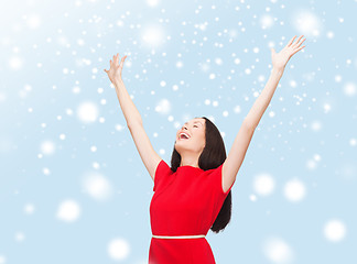 Image showing smiling young woman in red dress waving hands