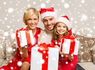 Image showing smiling family giving many gift boxes