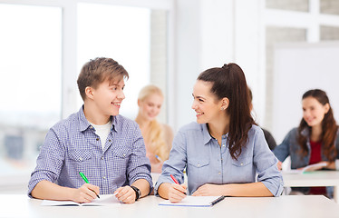 Image showing two teenagers with notebooks at school