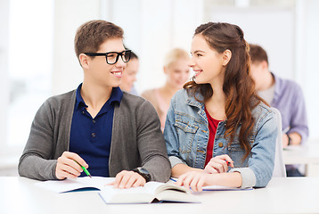 Image showing two teenagers with notebooks and book at school