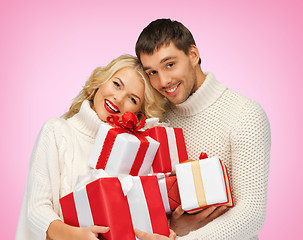 Image showing romantic couple in a sweaters with gift boxes