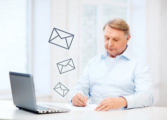 Image showing old man filling a form at home