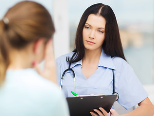 Image showing female doctor or nurse with patient