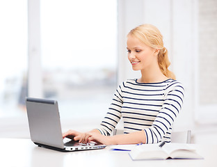 Image showing smiling student with laptop computer and notebook