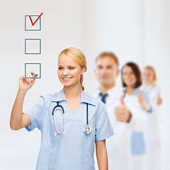 Image showing doctor or nurse drawing checkmark into checkbox