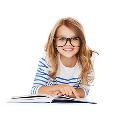 Image showing smiling little student girl lying on the floor