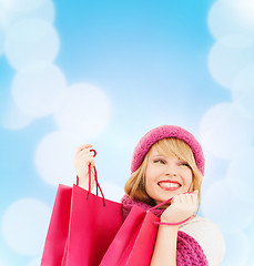 Image showing woman in pink hat and scarf with shopping bags