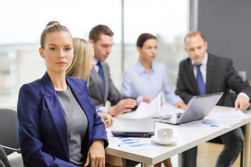 Image showing businesswoman in office with team on the back