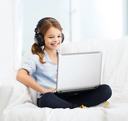 Image showing girl with laptop computer and headphones at home