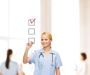 Image showing doctor or nurse drawing checkmark into checkbox