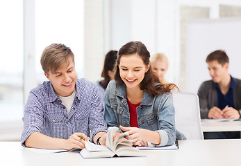 Image showing two teenagers with notebooks and book at school
