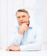 Image showing stressed old man holding head at home