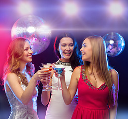 Image showing three smiling women with cocktails and disco ball