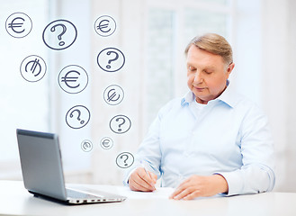 Image showing old man filling a form at home