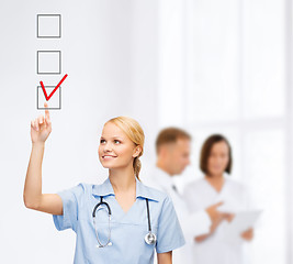 Image showing doctor or nurse drawning checkmark into checkbox