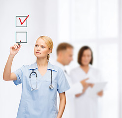 Image showing doctor or nurse drawning checkmark into checkbox